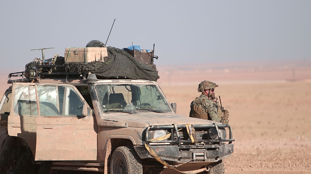 A US fighter stands near a military vehicle, north of Raqqa city, Syria [File: Rodi Said/Reuters]
