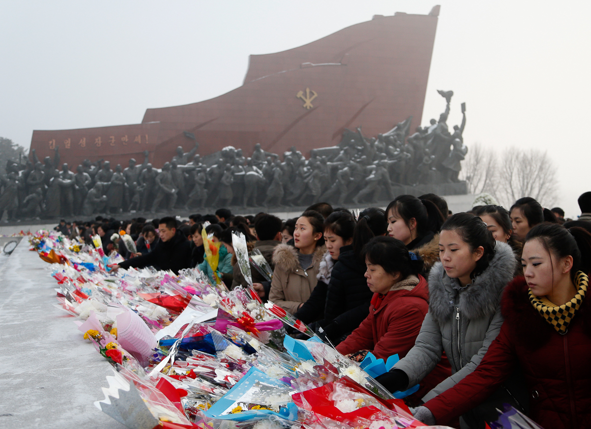 North Koreans lay flowers at the base of the bronze statues of their late leaders Kim Il Sung and Kim Jong Il at Mansu Hill Grand Monument in Pyongyang, North Korea, Monday, Dec. 17, 2018. Tens of tho