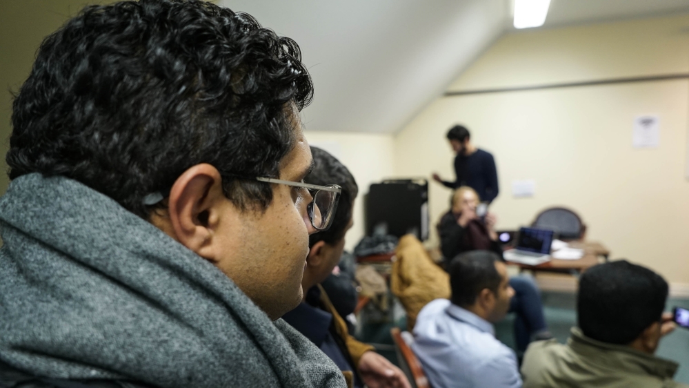 Ahmed Baider takes part in an interview with a Yemeni official at the Yemen Peace Newsroom's temporary office [Faisal Edroos/Al Jazeera]