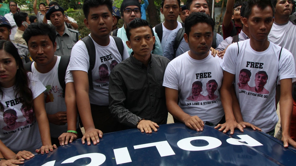Journalists stand in front of the police vehicle carrying Wa Lone and Kyaw Soe Oo to prison after the court verdict was announced in September [Myo Kyaw Soe/Reuters]