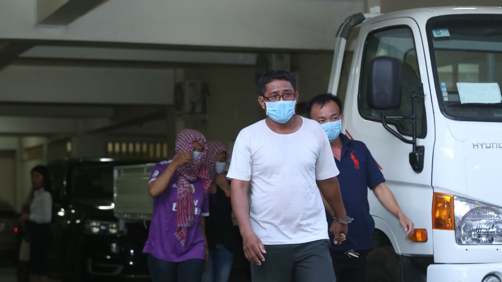 Four Cambodians arrested in a surrogacy sting in November shield their faces as they leave court. They allegedly worked as cooks and drivers for a group of 11 surrogate mothers living in Phnom Penh leading up to their delivery dates [Sineat Yon/Al Jazeera]