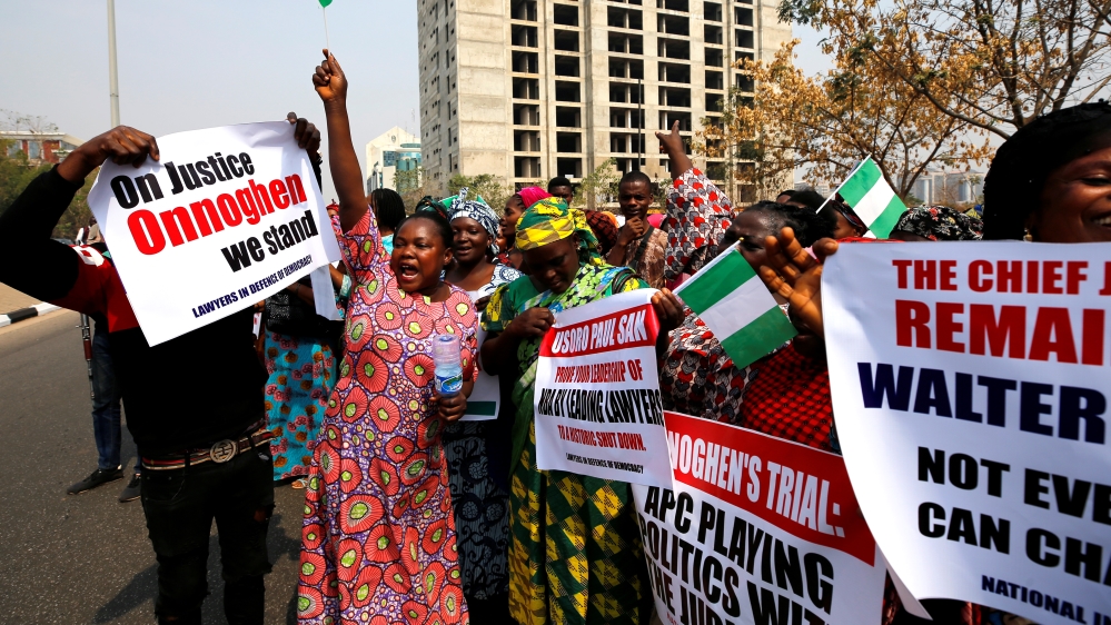 People hold banners during a protest over the suspension of the chief justice of Nigeria (CJN), Walter Onnoghen, in Abuja