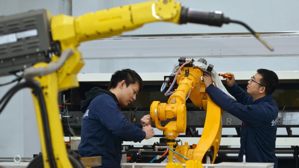 Men work on a production line manufacturing robotic arms at a factory in Huzhou, Zhejiang