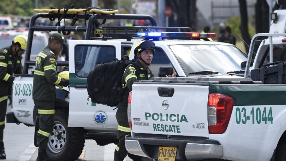 Security forces work at the site of a car bomb attack on a police cadet training school in Bogota [Juan Barreto/AFP]