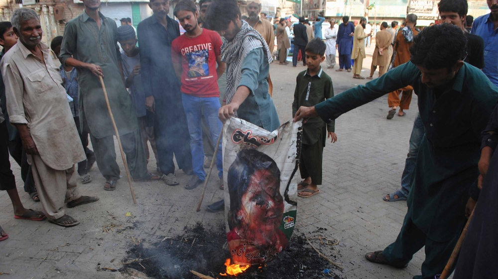 Pakistani protesters burn a poster image of Christian woman Aasia Bibi in Hyderabad, Pakistan [File: Pervez Masih/AP]