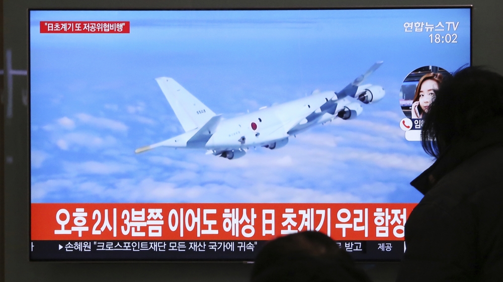 People watch a TV screen showing file footage of a Japanese patrol plane during a news program at the Seoul Railway Station in Seoul, South Korea, Wednesday, Jan. 23, 2019.