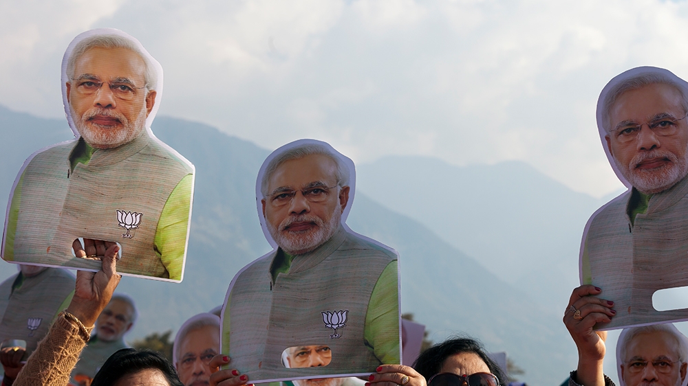 Supporters carry cutouts of the Indian Prime Minister Narendra Modi at a gathering organized to mark the completion of one year of the Bharatiya Janata Party government in Himachal Pradesh, in Dharmsa