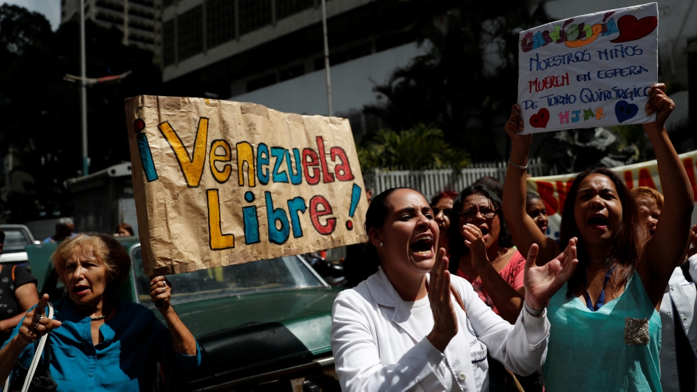 Supporters of Venezuelan opposition leader hold a banner reading