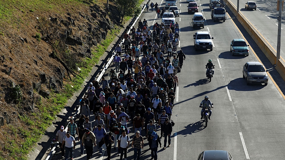 Salvadorans take part in a new caravan of migrants and refugees, set to head to the US, as they leave San Salvador, El Salvador [Jose Cabezas/Reuters] 