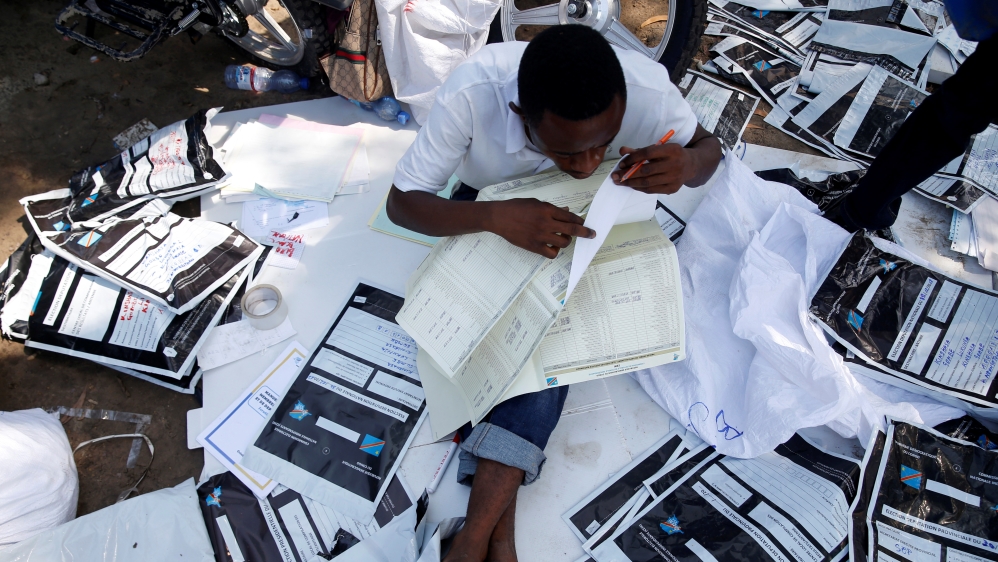 Man examines voting materials at CENI tallying centre in Kinshasa