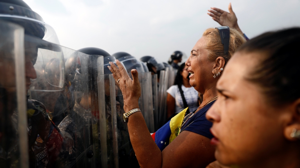 Venezuela's opposition supporters demand to cross the border line between Colombia and Venezuela at Simon Bolivar bridge [Edgard Garrido/Reuters]