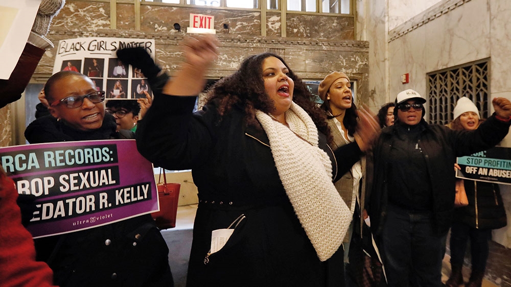 Sonja Spoo, centre, associate campaign director of Ultra Violet, leads chants during an R Kelly protest in the lobby of Sony headquarters, in New York [Richard Drew/AP Photo] 