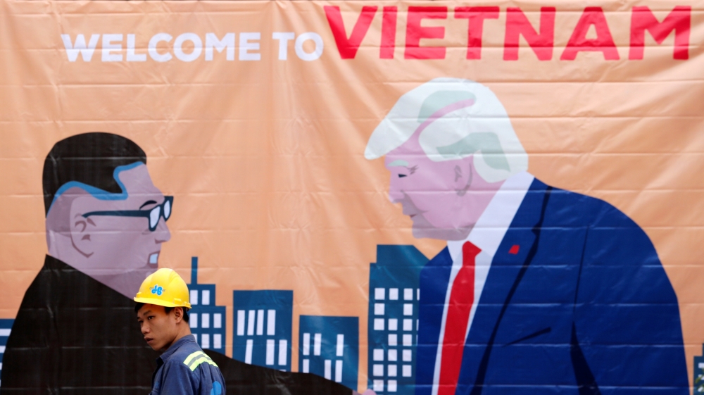 A man walks past a banner depicting North Korean leader Kim Jong Un and U.S. President Donald Trump ahead of the North Korea-U.S. summit in Hanoi