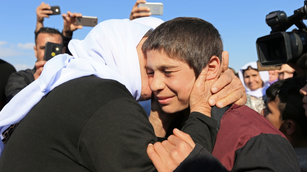 A relative kisses a Yazidi survivor boy following his release from Islamic State militants in Syria, in Duhok