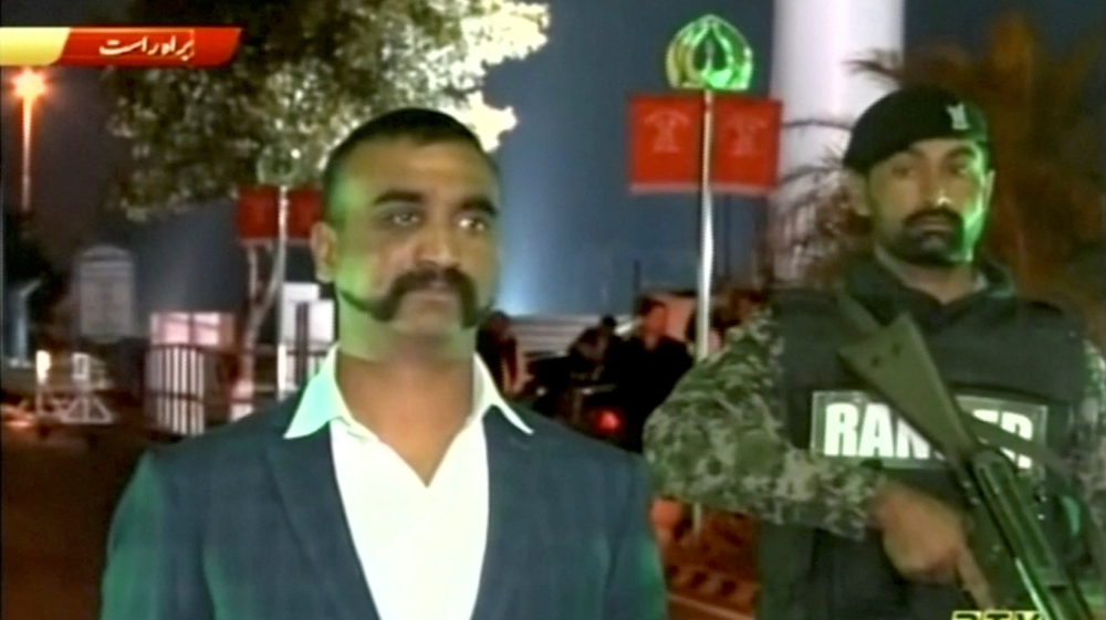 Varthaman crosses over into India by foot, escorted by Pakistani troops and Indian diplomats [PTV via Reuters]