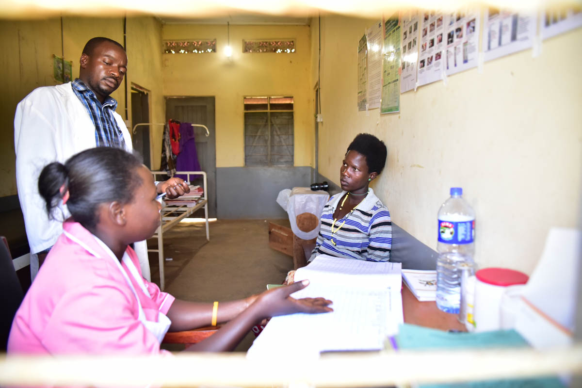 Naigaga Sandra (R) 18 years old and 7 months pregnant listens to Musomba Joshua and Namuswa Juliet an enrolled midwife at the Kibibi health center in Budondo sub county in Jinja District in the Easter