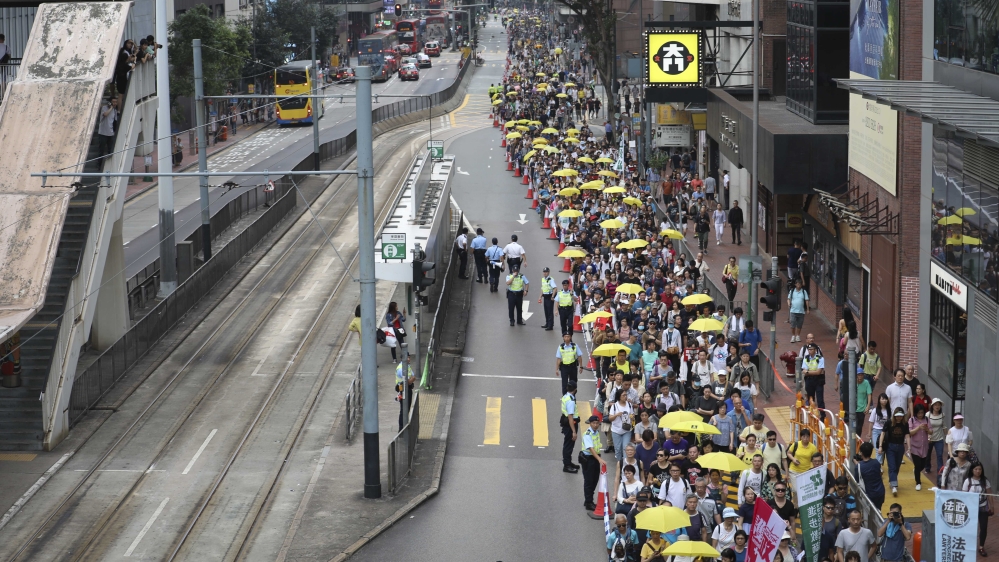 Demonstrator hold yellow umbrella in a protest against the extradition law amendments [James Wendlinger/Al Jazeera]
