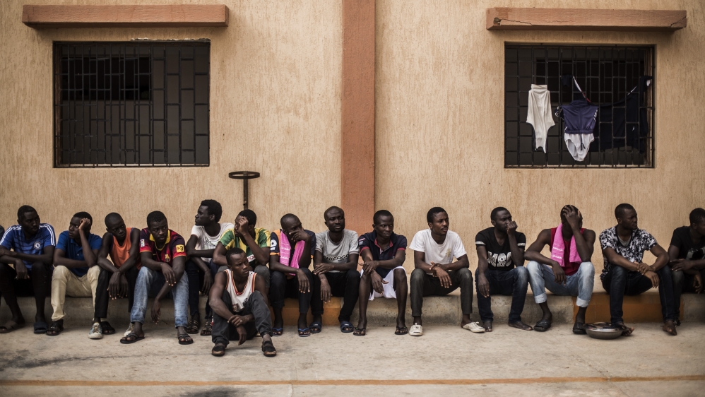 Migrants wait to get in their barracks after having lunch in the courtyard of a detention center for migrants, in the village of Karareem, around 50 km from Misrata, Libya, Sunday, Sept. 25, 2016