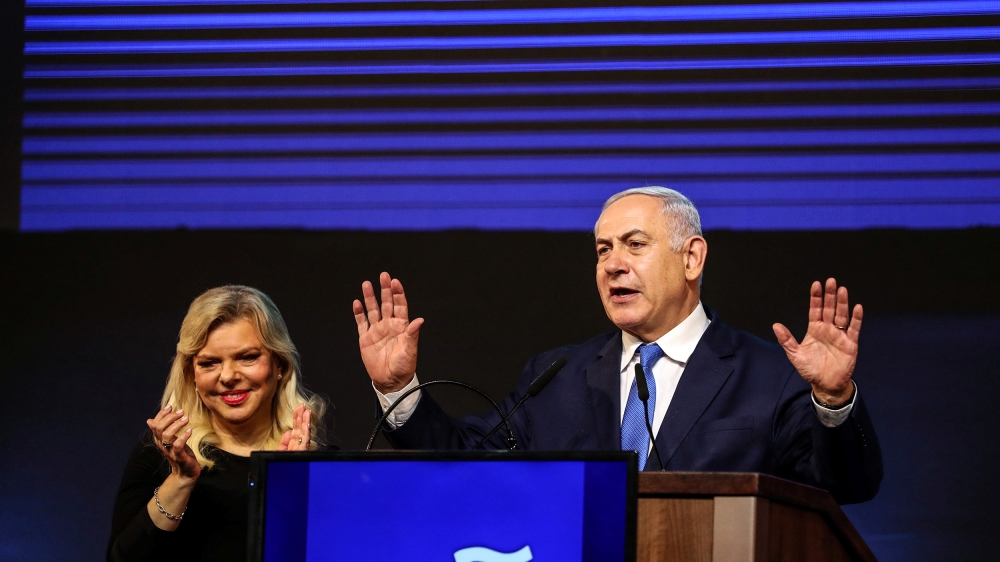 Israeli Prime Minister Benjamin Netanyahu and his wife Sara gesture as Netanyahu speaks following the announcement of exit polls in Israel''s parliamentary election at the party headquarters in Tel Av