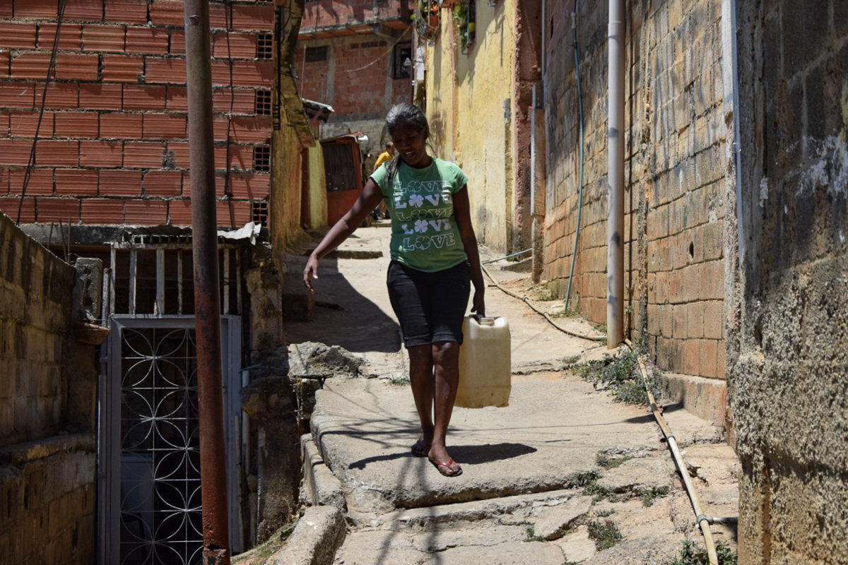 “I have spent 27 years carrying water,” Elena said, there is never water in this neighbourhood” [Elizabeth Melimopoulos/Al Jazeera]