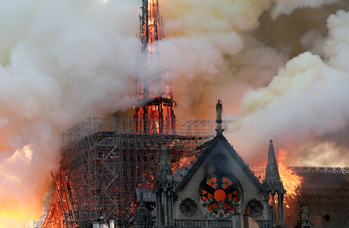Smoke billows as fire engulfs the spire of Notre Dame Cathedral in Paris, France April 15, 2019. REUTERS/Benoit Tessier -