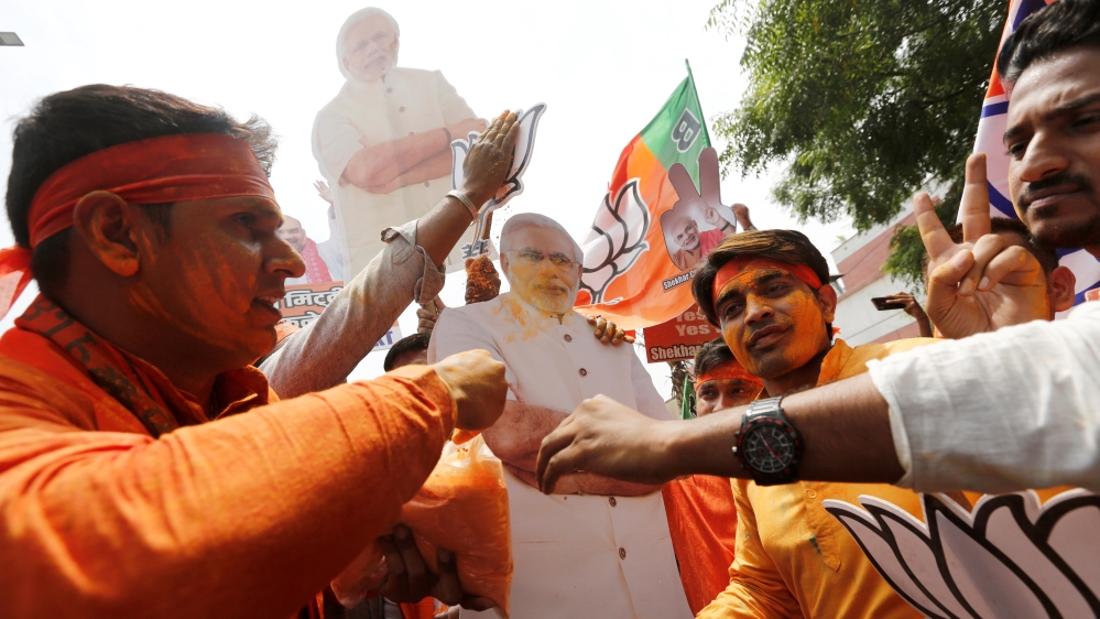 BJP supporters celebrate after learning the initial election results in New Delhi