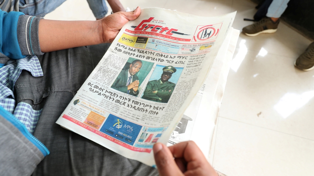 An Ethiopian man reads a newspaper with the pictures of Amhara state President Ambachew Mekonnen, killed in the region''s main city Bahir Dar, and of Army Chief of Staff Seare Mekonnen, who was shot b