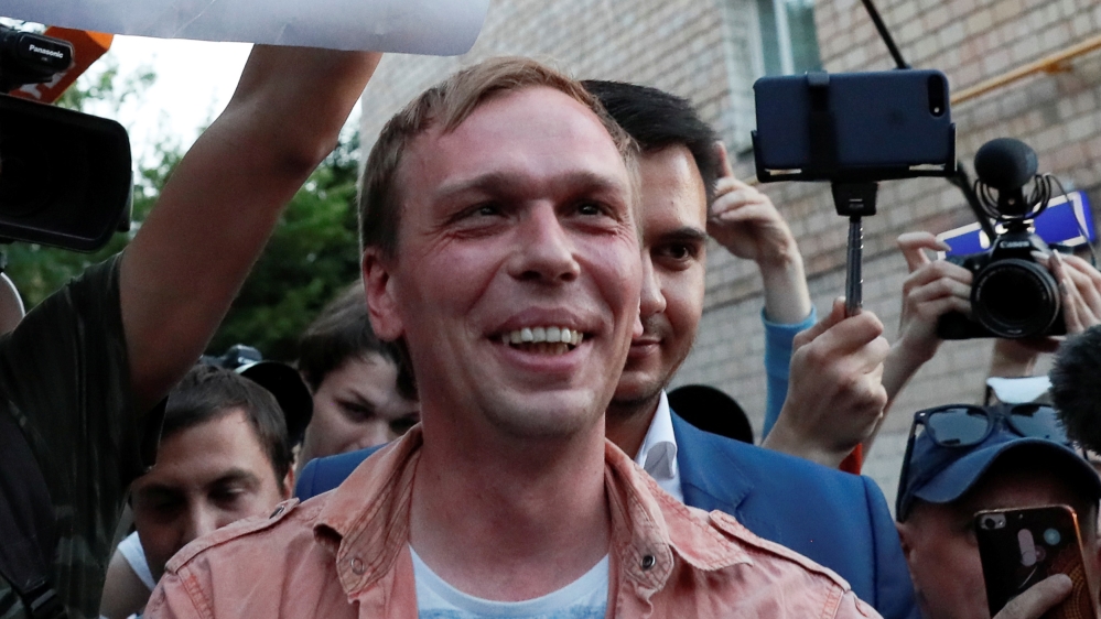 Russian journalist Ivan Golunov (R), who was freed from house arrest after police abruptly dropped drugs charges against him, meets with the media and his supporters outside the office of criminal inv