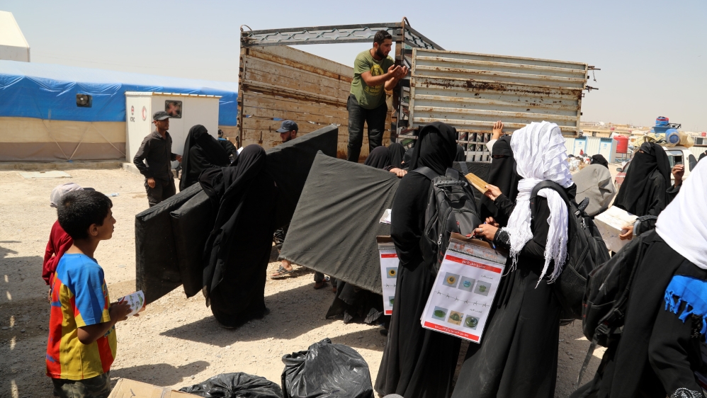 Wives of Islamic state fighters (IS) load their belongings into a truck upon their deportation from the al-Hol camp for refugees in al-Hasakah governorate in northeastern Syria on 03 June 2019
