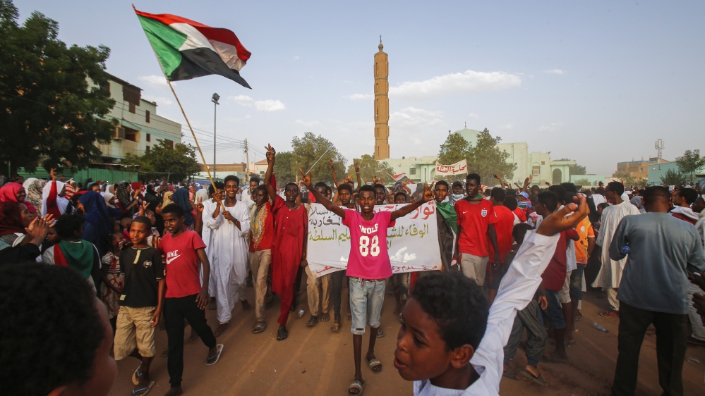 Sudanese people chant slogans and wave national flags as they celebrate in Khartoum