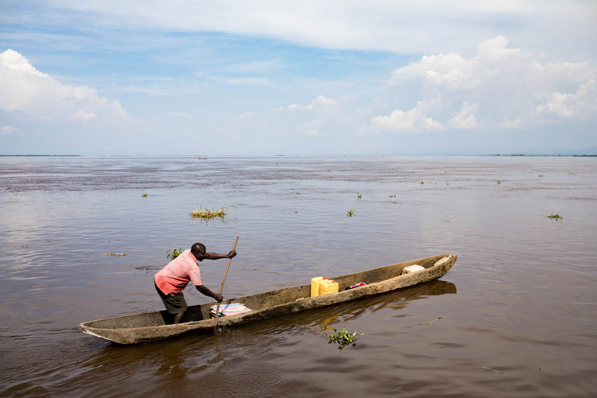 A man carries some goods in a canoe. He does not adhere to the militia but believes strongly in their magical powers.