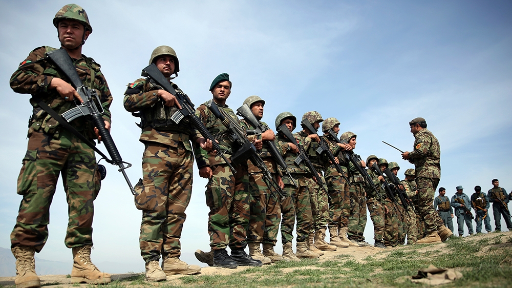 In this Tuesday, March 15, 2016 file photo, Afghan National Army soldiers stand guard, following weeks of heavy clashes to recapture the area from Taliban militants in Dand-e Ghouri district in Baghl