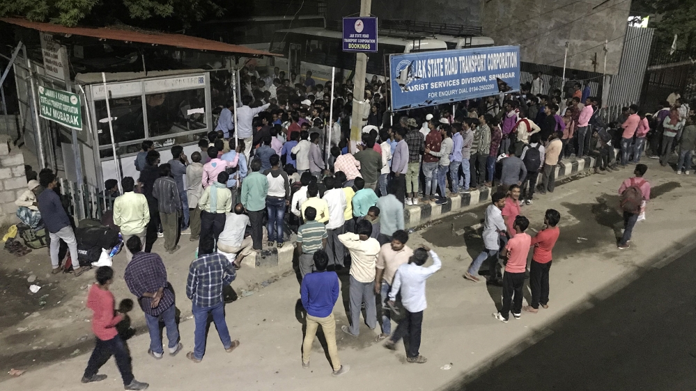 People from various parts of India wait at a bus terminal during restrictions as they wait to leave Srinagar [Zubair Sofi/Al Jazeera]