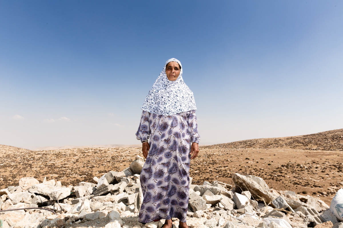 Huda in front of her demolished house.