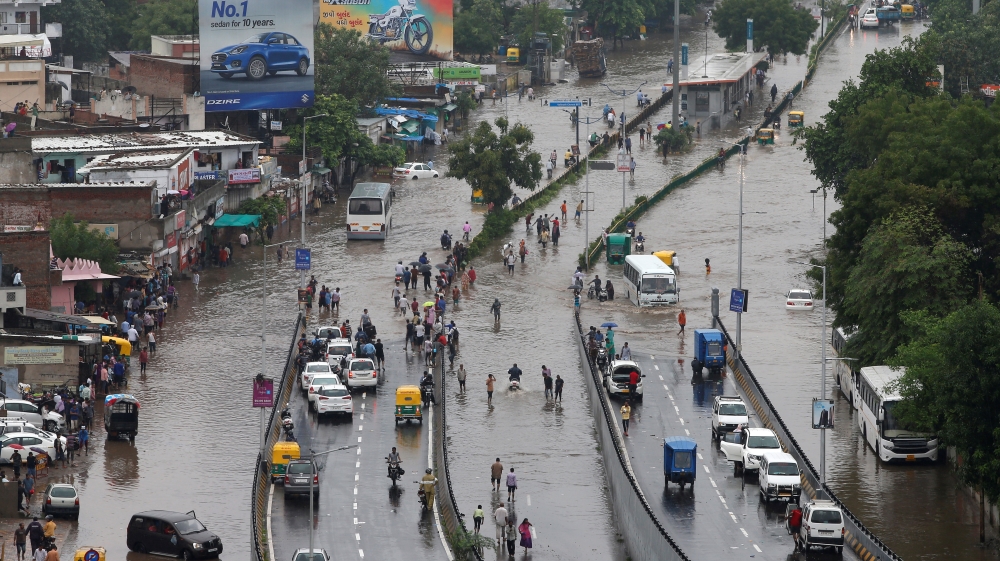 People commute through water-logged roads after heavy rains in Ahmedabad