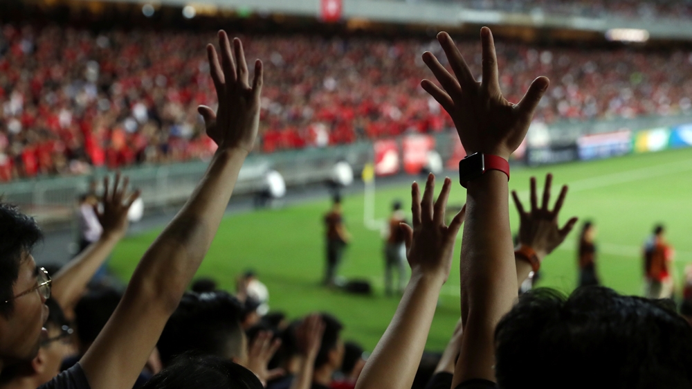 Soccer fans gesture their hands in support of anti-government protesters during a football World Cup qualifier match between Hong Kong and Iran, at Hong Kong Stadium, China September 10, 2019. REUTERS