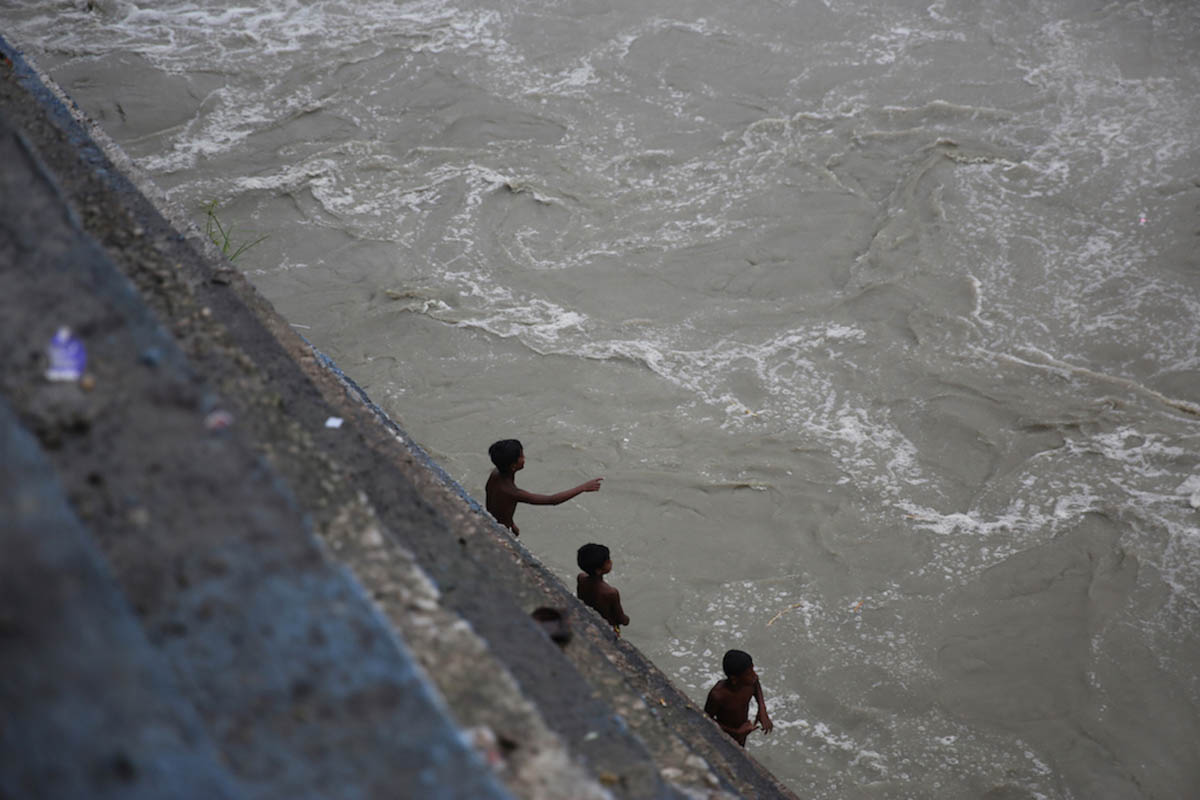 Many children from the tribal community have quit schooling due to lack of resources and now do small odd jobs to compensate the family income. Kids are seen here risking their lives to find logs of w