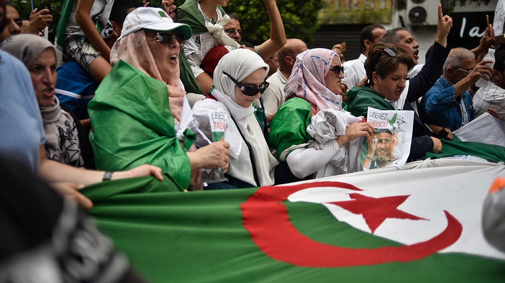 Algerian protesters chant slogans and wave their national flag during a demonstration against the ruling class in the capital Algiers on September 13, 2019, for the 30th consecutive Friday since the m