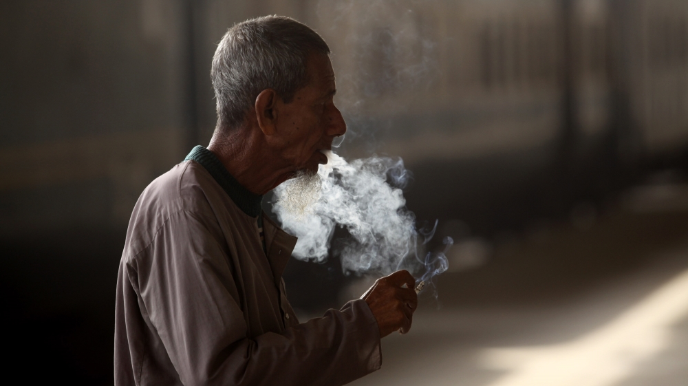 A man smokes a cigarette as he waits for a train at the platform of the central railway station in Dhaka, Bangladesh, 09 December 2013