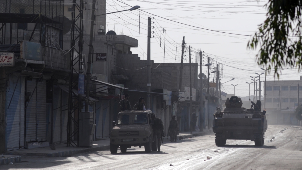 Turkey-backed Syrian rebel fighters are seen on military vehicles in the town of Tal Abyad