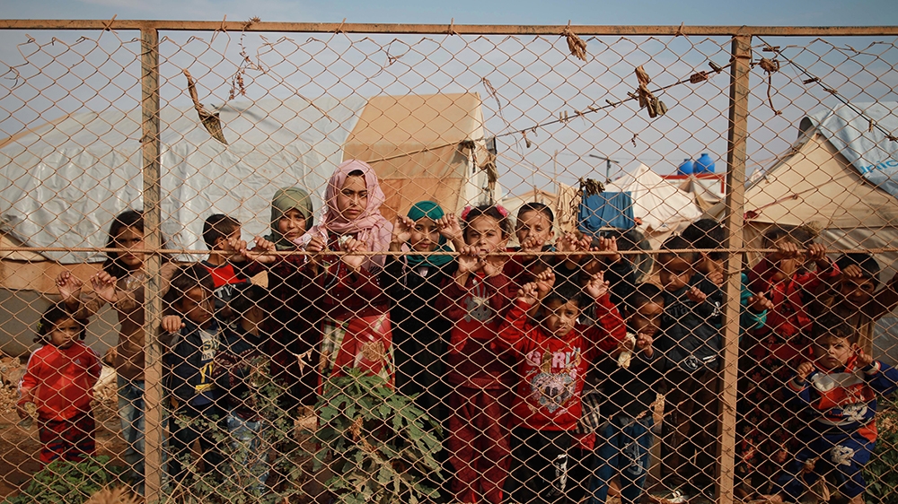 Displaced Syrian children stand behind a fence outside their tents a camp set up near the village of Kafr Lusin, in Idlib''s northern countryside near the Syria-Turkey border, on October 22, 2019. - Th