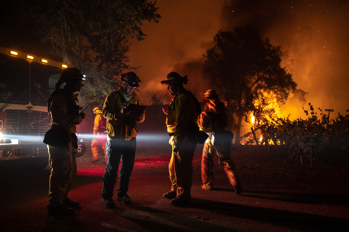 Firefightes plan their move as a building burning out of control, as the Kincade Fire continues to burn in Healdsburg, California, USA, 27 October 2019. According to reports, the Kincade Fire has bu