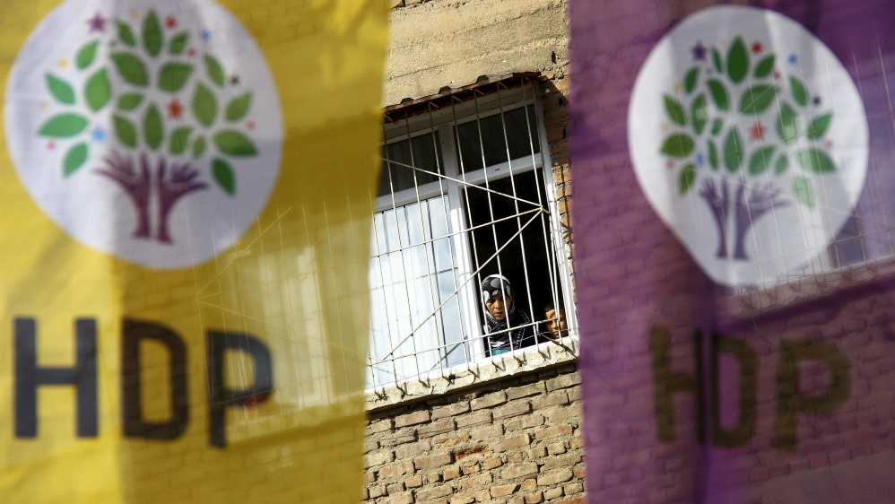 Woman and a boy look out of a balcony as election banners of the pro-Kurdish Peoples'' Democratic Party (HDP) hang outside in Diyarbakir