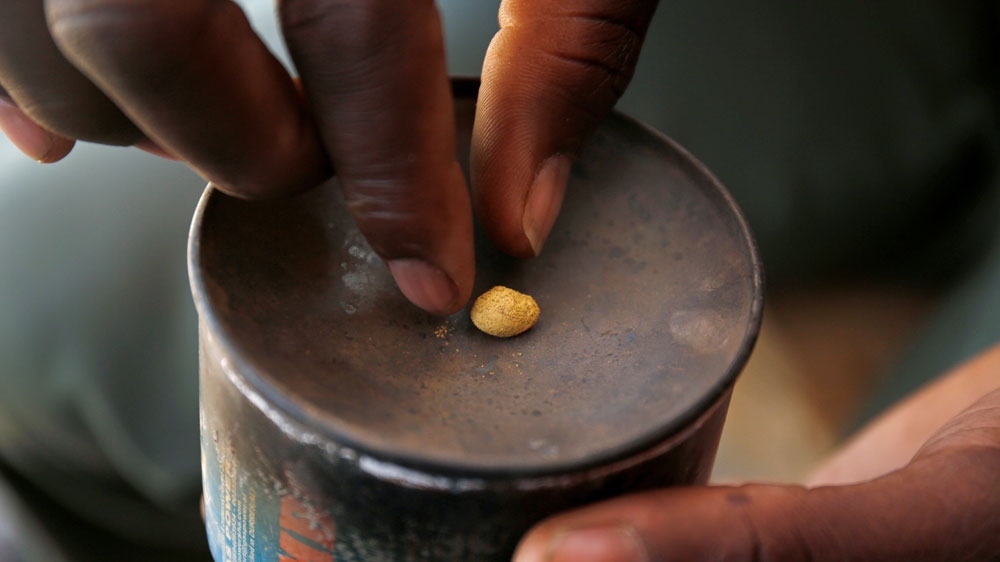 An artisanal gold miner picks up a gold nugget at an unlicensed mine in Gaoua, Burkina Faso