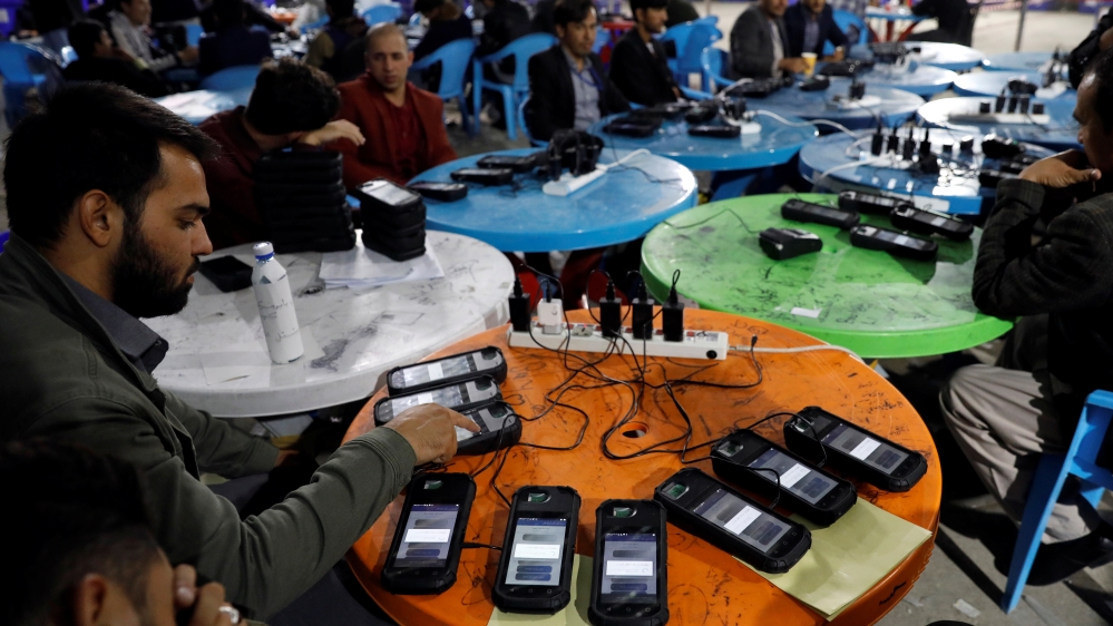 Afghan election commission workers transfer data from biometric devices to the main server at a warehouse in Kabul
