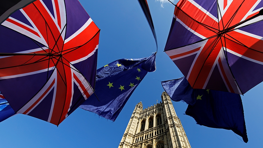 EU and Union flags belonging to both anti-Brexit and pro-Brexit activists, fly outside the Houses of Parliament in London on October 22, 2019, as MPs begin debating the second reading of the Governmen