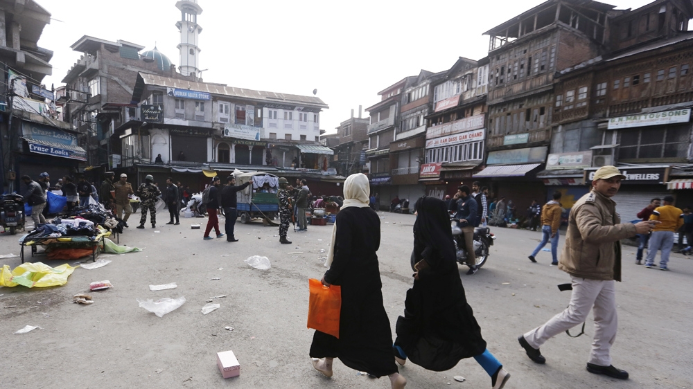 Kashmiri residents run at the site of a grenade blast in Srinagar
