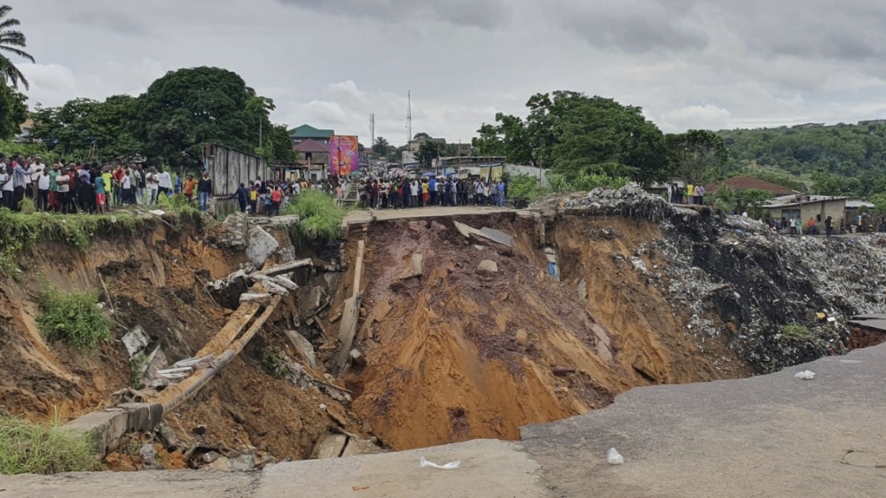 A road surface swept away by a landslide caused by torrential overnight rains is photographed in the Lemba district of Kinshasa, on November 26, 2019. Thirty-six people died in the Lemba district of t