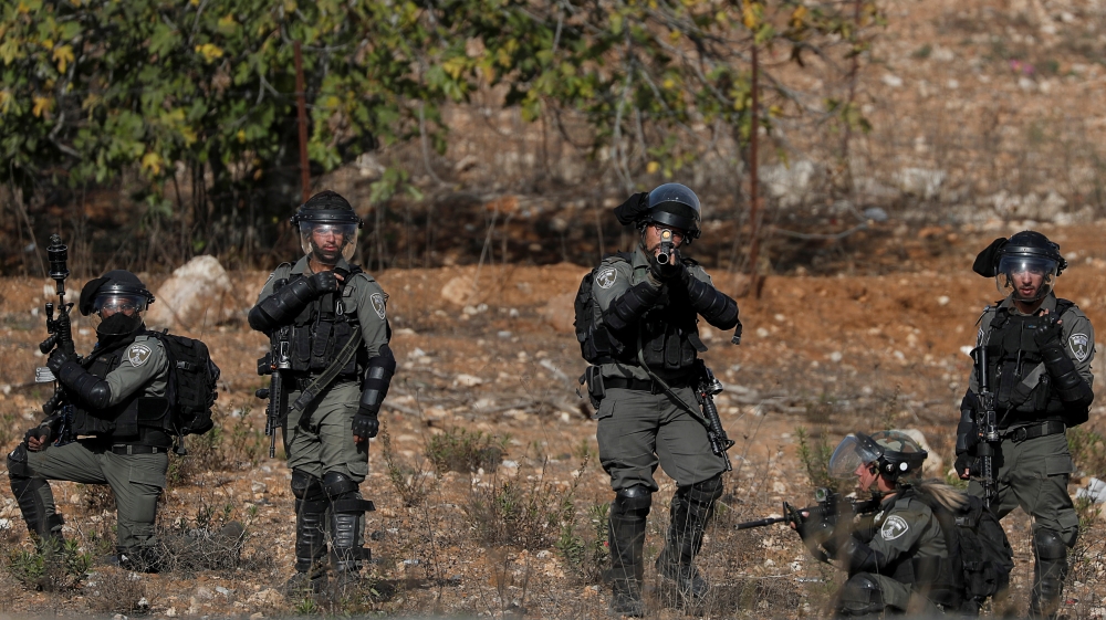 An Israeli border police officer aims his weapon during a protest as Palestinians call for a day of rage in the Israeli-occupied West Bank