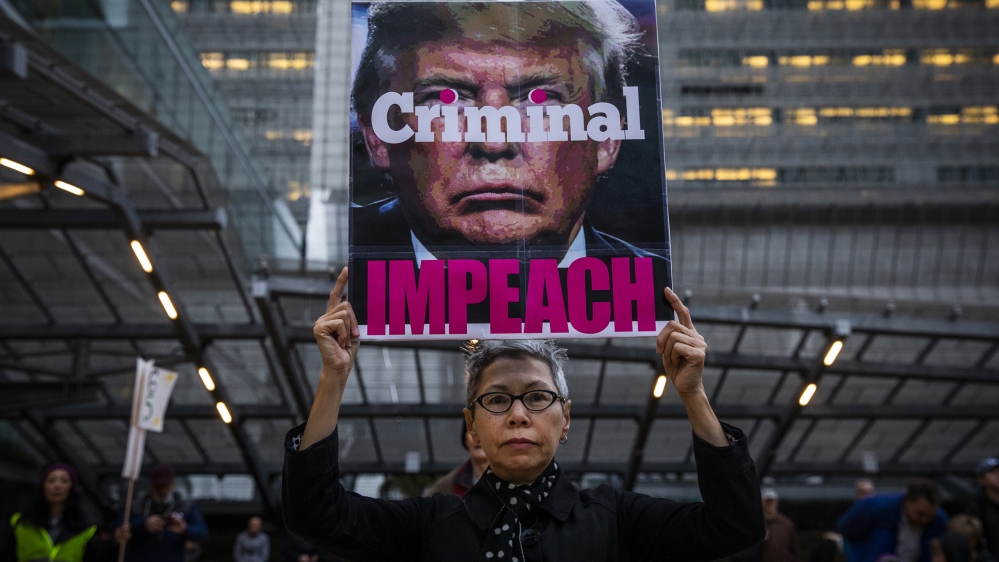 Connie Jeung-Mills of San Francisco holds a sign during a demonstration in part of a national impeachment rally, at the Federal Building in San Francisco, California. Protesters around the nation part